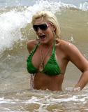 Brooke Hogan in green bikinis posing at the beach